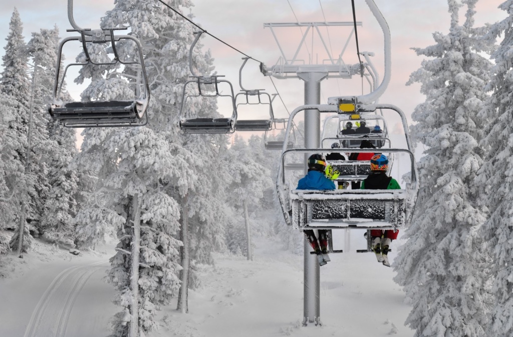 People riding chair lift at ski resort