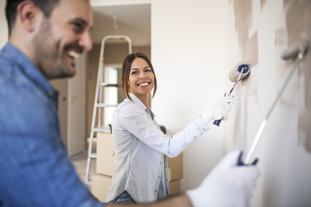 Couple painting their home before selling